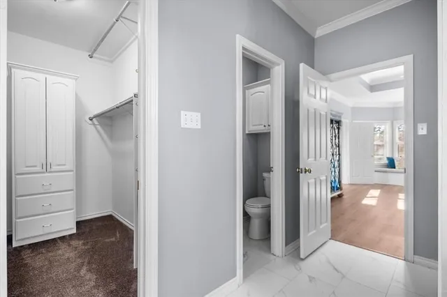 a view of a hallway with bathroom and a bathroom
