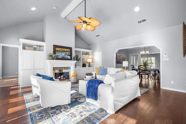 a living room with furniture a chandelier and a fireplace