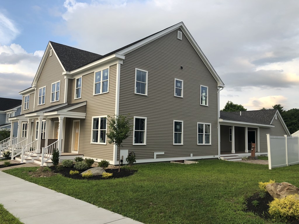 92 Grant Road, Unit A Devens, MA 01434 - Photo 1 of 5 a front view of a house with a garden