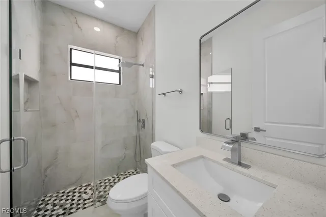 a bathroom with a sink a toilet and shower