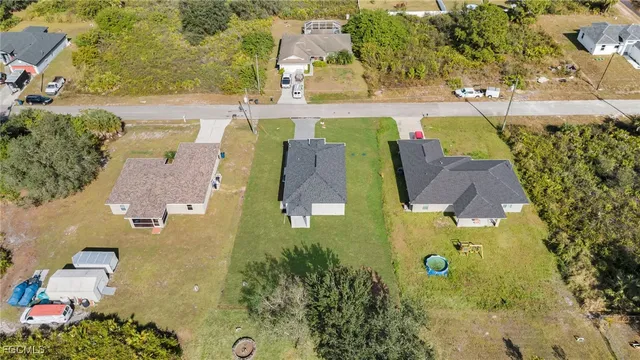 an aerial view of residential houses with outdoor space and parking