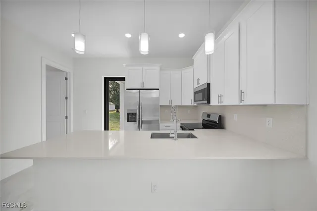 a kitchen with kitchen island a sink stainless steel appliances and cabinets