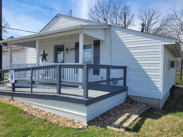 a view of a house with a small yard and wooden floor and fence
