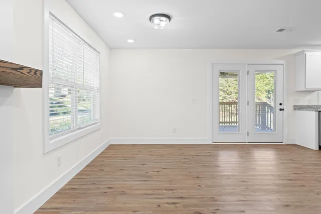 a kitchen with stainless steel appliances granite countertop a stove top oven a sink and white cabinets