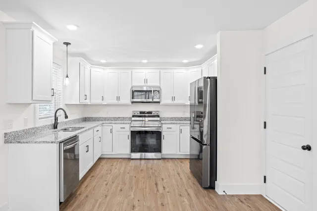 a kitchen with stainless steel appliances granite countertop a refrigerator stove top oven and sink