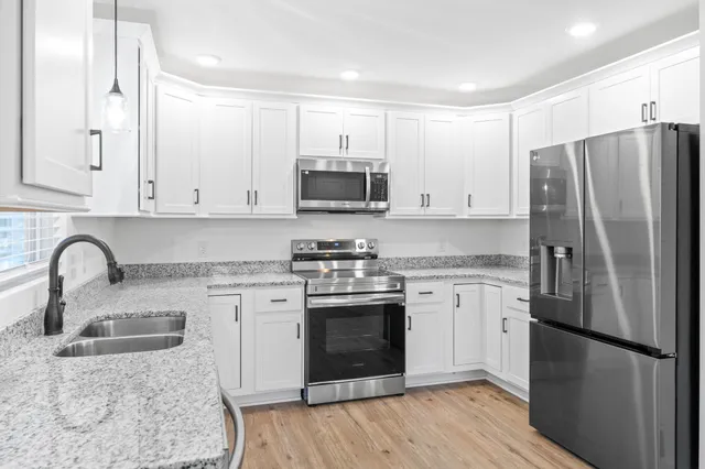 a kitchen with granite countertop white cabinets and a window