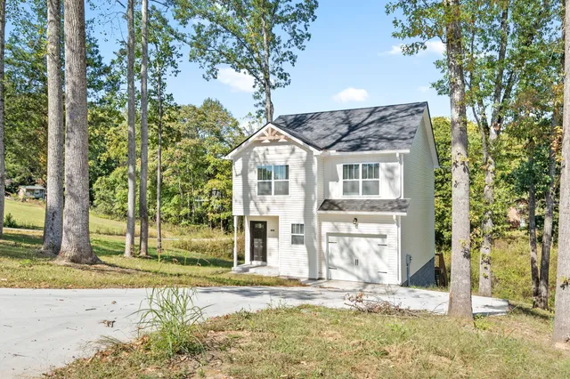 front view of a house with a tree in the background