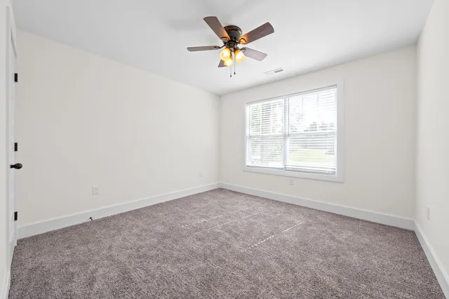 an empty room with closet and a chandelier fan