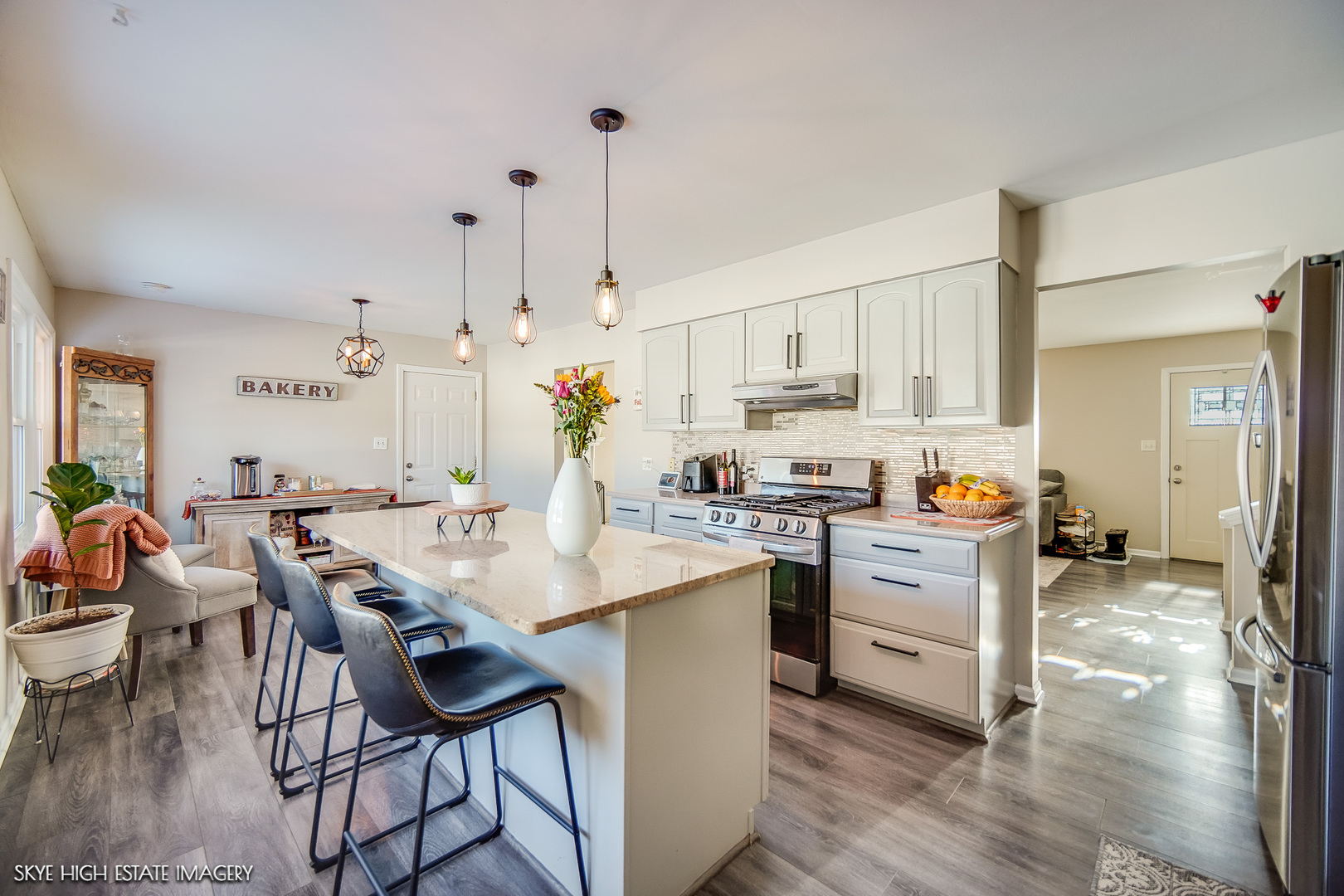 113 April Lane North Aurora, IL 60542 - Photo 7 of 23 a open kitchen with stainless steel appliances kitchen island granite countertop a stove a sink a dining table and chairs with wooden floor