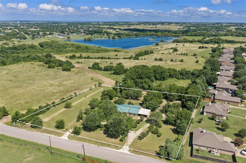 440 Williams Road Lorena, TX 76655 - Photo 2 of 19 Expansive property featuring a single-story residence with a green metal roof, surrounded by mature trees