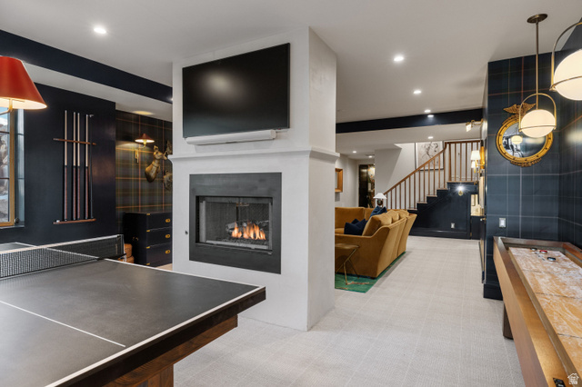 558 West Rheinfalls Circle Midway, UT 84049 - Photo 31 of 61 Sophisticated recreation space anchored by a gas fireplace with built-in television, complemented by a slate-topped pool table, light-filled ceiling with recessed and pendant lighting, and navy accent walls with white trim detailing throughout the open-co