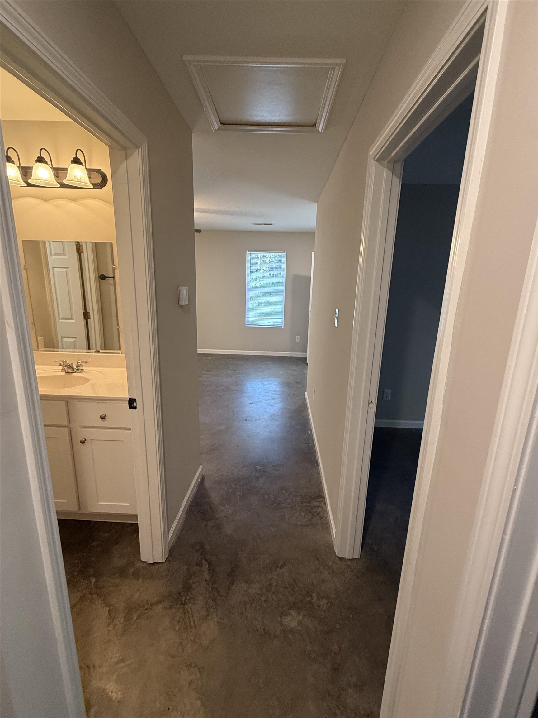 4589 Range Line Road Memphis, TN 38127 - Photo 21 of 25 Hallway with unfinished concrete flooring and attic access