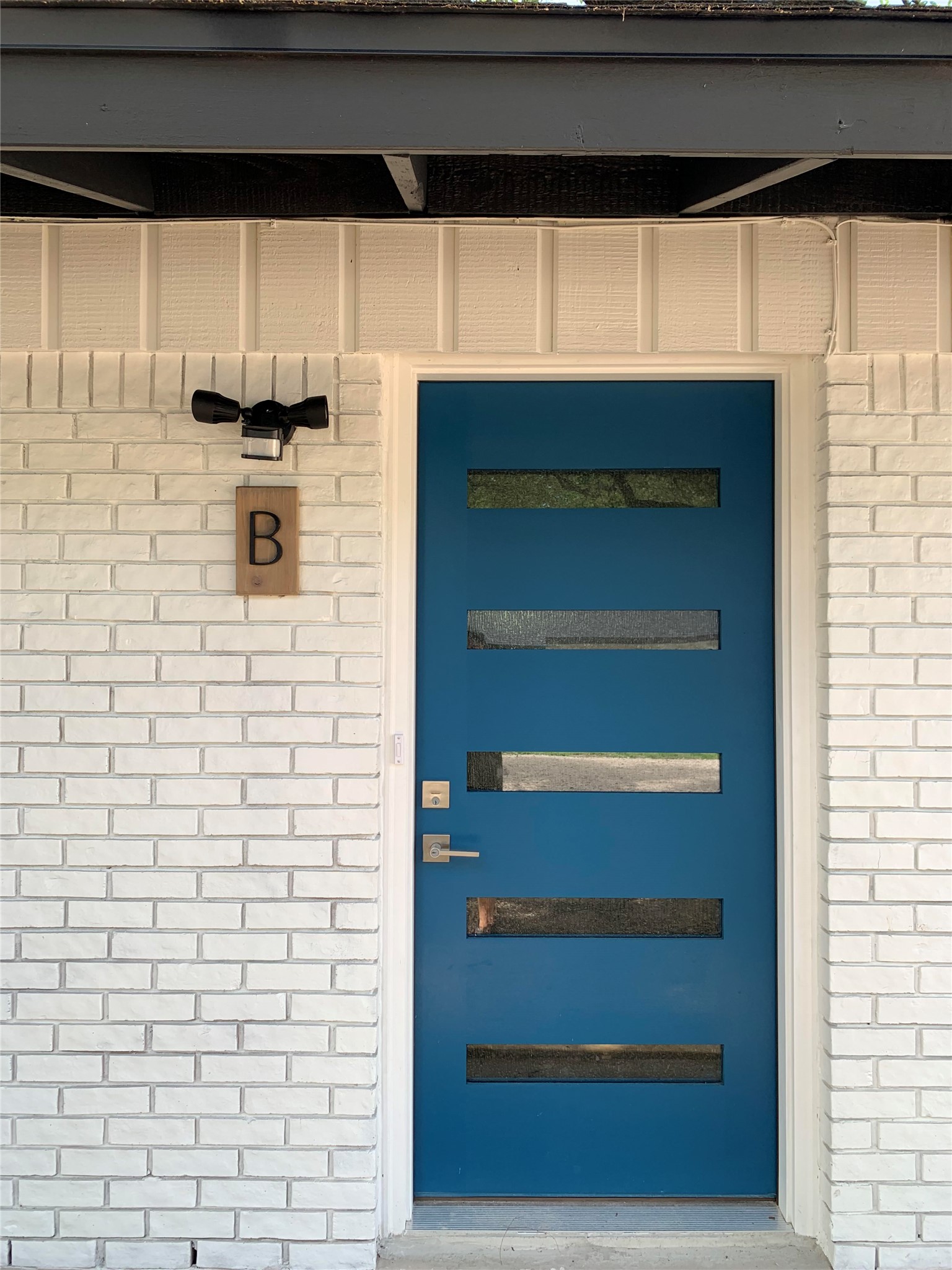 6706 Circle S Road, Unit B Austin, TX 78745 - Photo 6 of 18 A stylish modern entry features textured brickwork and vertical board and batten siding.