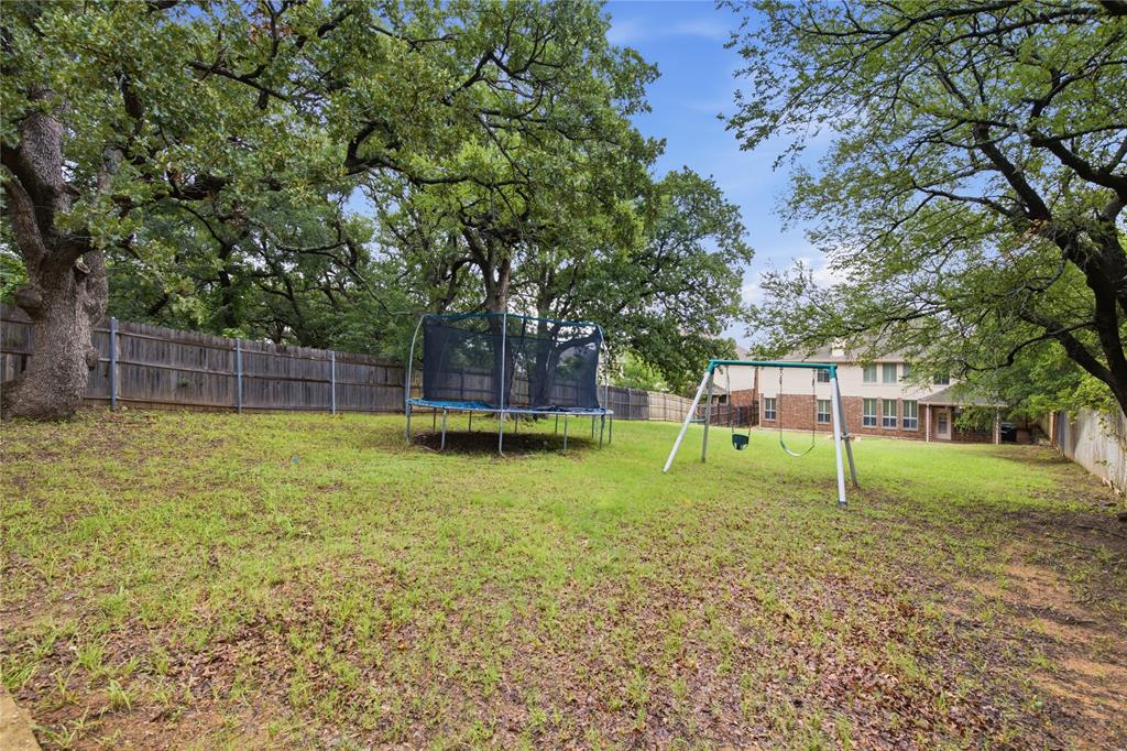 10001 Thurman Road Fort Worth, TX 76244 - Photo 35 of 40 Expansive rear yard featuring mature trees and a wood privacy fence