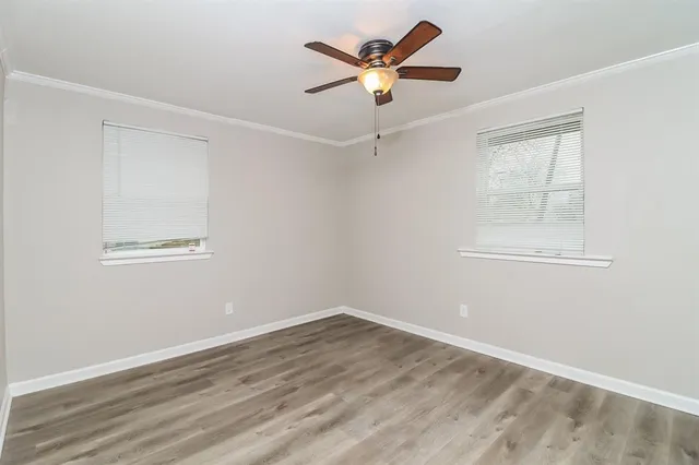 an empty room with a window and a fan