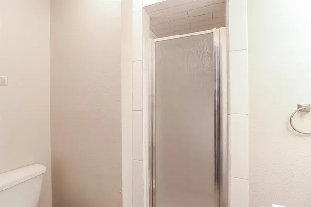 a bathroom with a granite countertop toilet and a sink