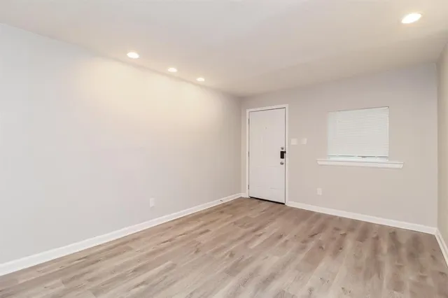 a view of an empty room with wooden floor