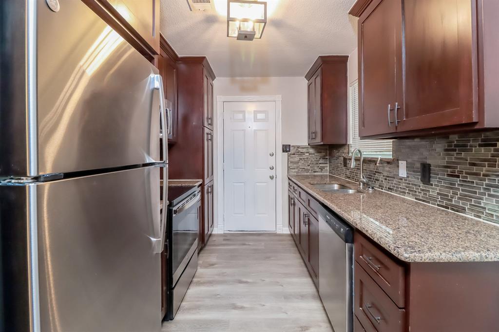 4117 Hatcher Street Fort Worth, TX 76119 - Photo 7 of 16 a kitchen with stainless steel appliances granite countertop a refrigerator a stove and a sink