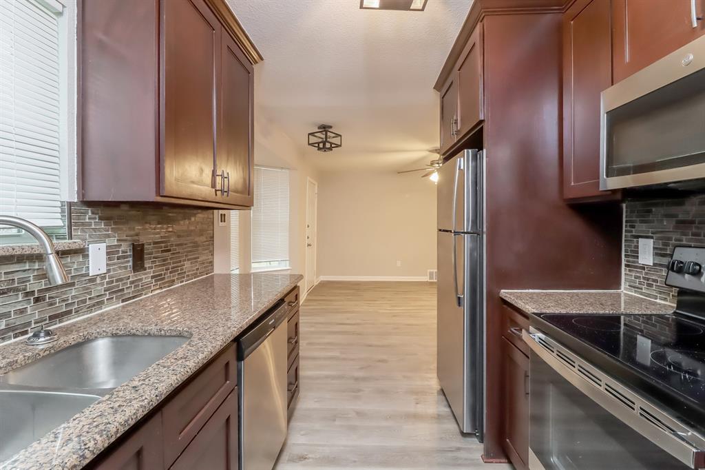 4117 Hatcher Street Fort Worth, TX 76119 - Photo 8 of 16 a kitchen with granite countertop a sink stove and refrigerator
