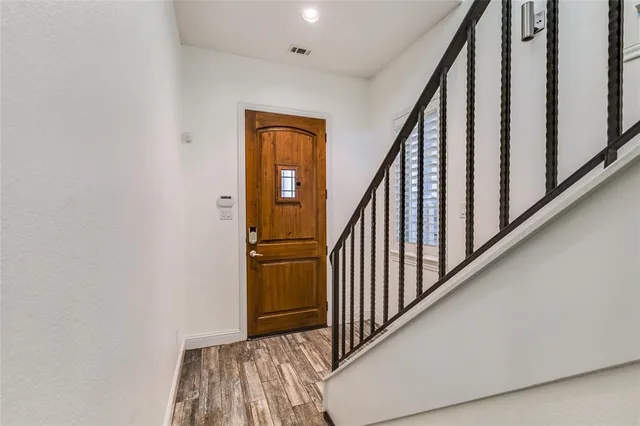 a view of a hallway with wooden floor and staircase
