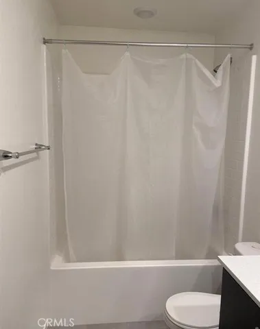 a bathroom with a shower curtain and a toilet