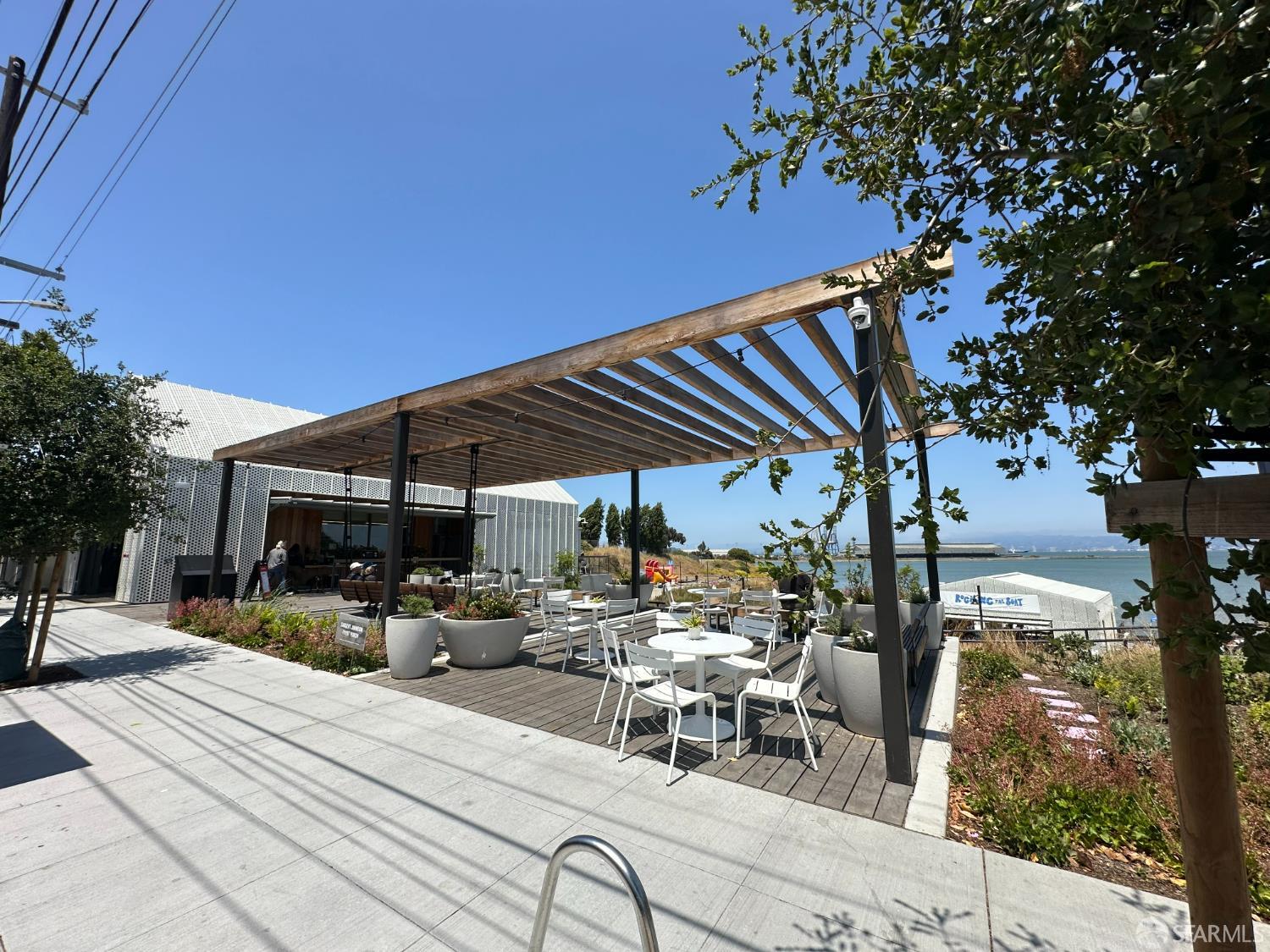 134 Albatross Court San Francisco, CA 94124 - Photo 40 of 40 a view of a patio with table and chairs under an umbrella with large tree