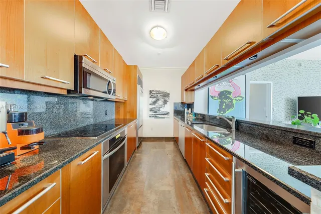 a kitchen with stainless steel appliances granite countertop sink stove and cabinets