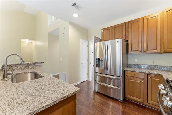 a kitchen with granite countertop a refrigerator and a sink