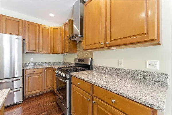 a kitchen with stainless steel appliances granite countertop a sink a stove and a refrigerator