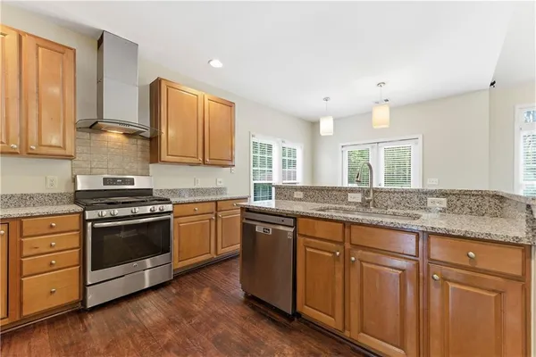 a kitchen with granite countertop wooden cabinets and a stove