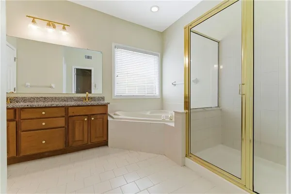 a spacious bathroom with a granite countertop sink mirror and a bathtub