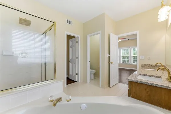 a bathroom with a tub sink and mirror