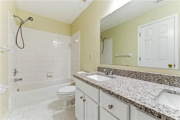 a bathroom with a granite countertop sink a toilet and shower