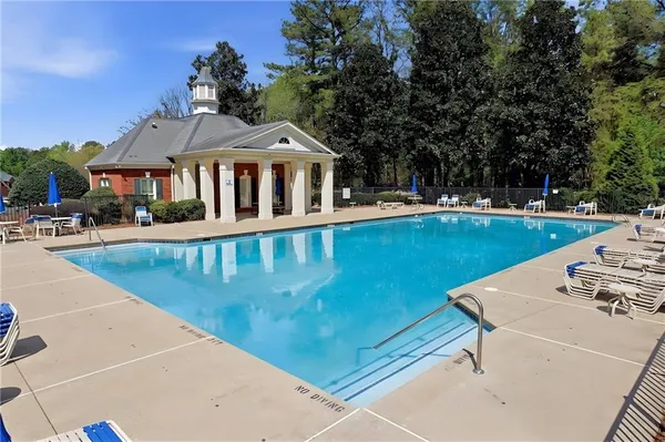 a view of a house with pool and chairs