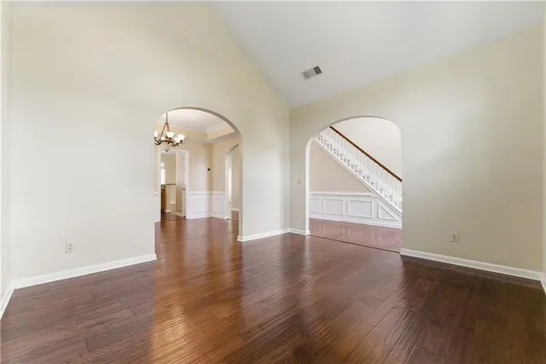 an empty room with wooden floor and mirror
