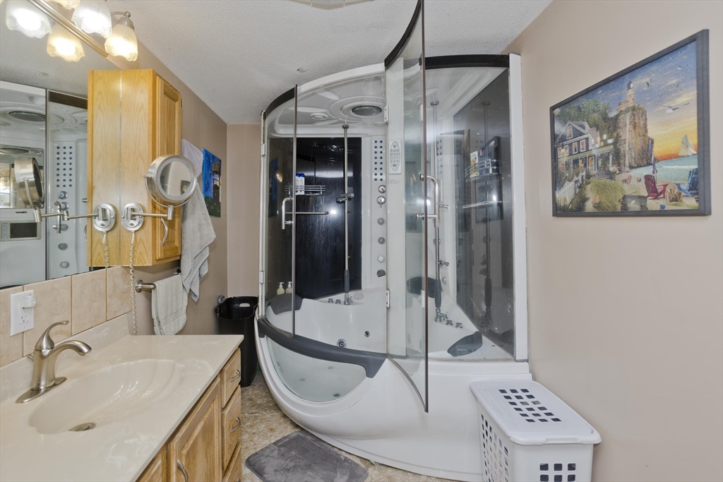 391 Plumtree Road Springfield, MA 01118 - Photo 23 of 42 a bathroom with a sink a mirror and a shower