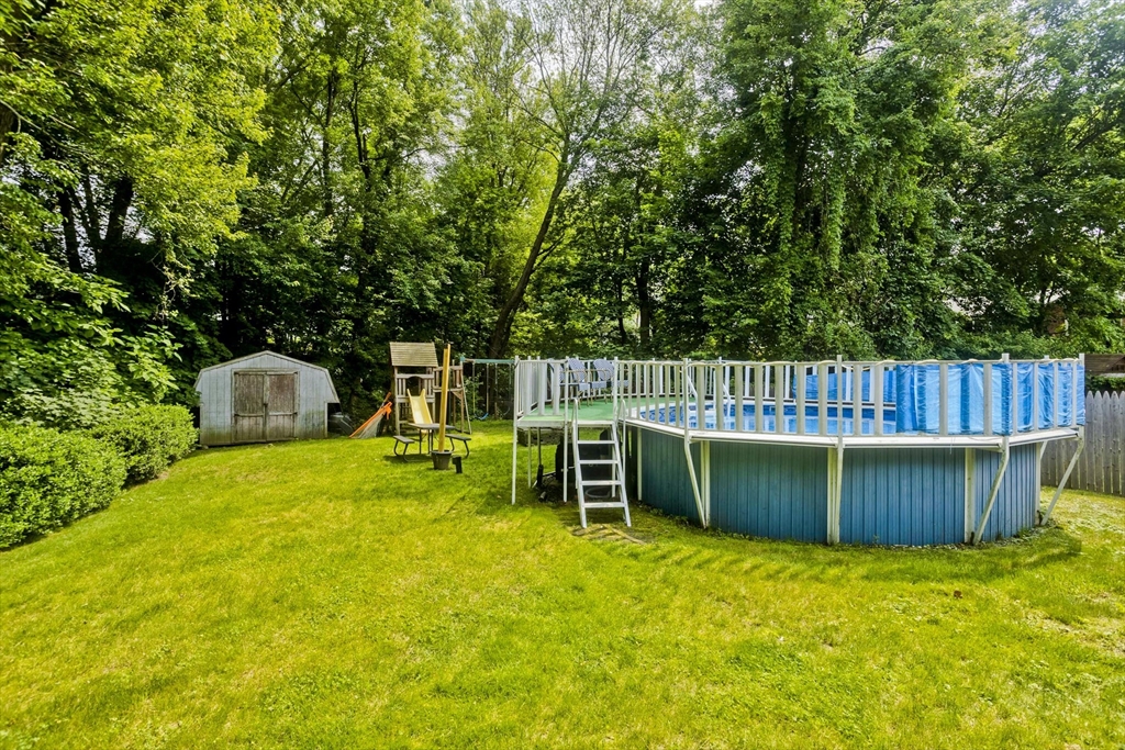 391 Plumtree Road Springfield, MA 01118 - Photo 5 of 42 a view of a backyard with wooden fence and a tree