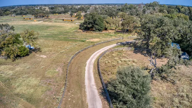 an aerial view of a house with a yard and lake