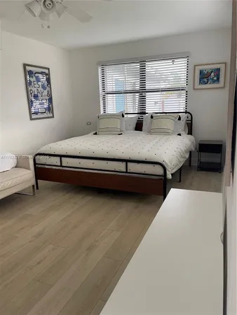 a bedroom with a bed large window and wall painting