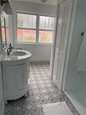 a bathroom with a sink a toilet and a window