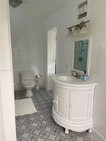 a bathroom with a sink a toilet and a mirror