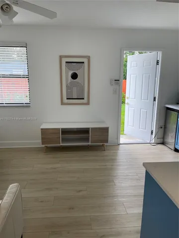 a view of a livingroom with wooden floor and a flat screen tv