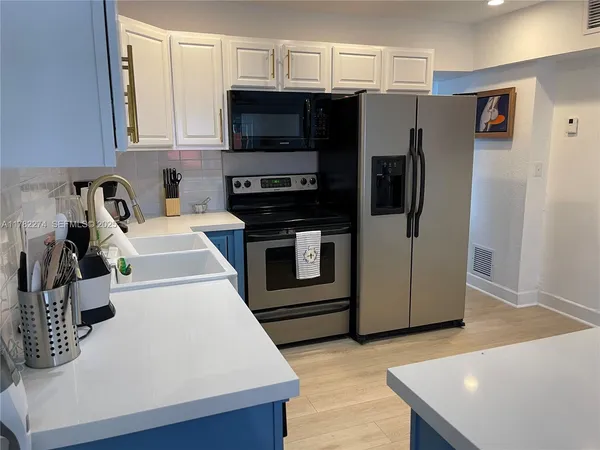 a kitchen with stainless steel appliances a stove a microwave and a refrigerator