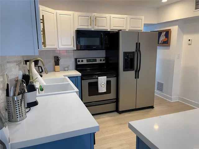a kitchen with stainless steel appliances a stove a microwave and a refrigerator