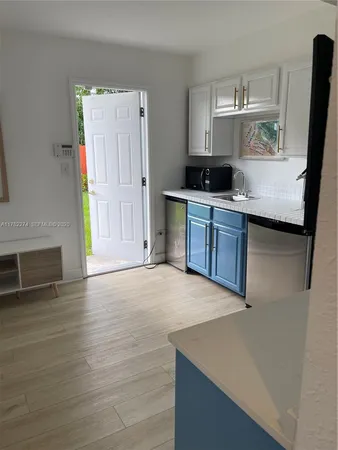 a kitchen with cabinets and wooden floor