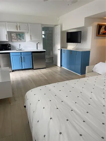 a living room with a bed and flat screen tv