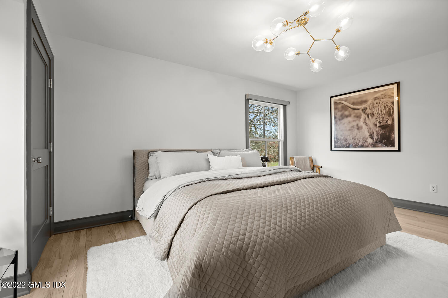 14 Copper Beech Road Greenwich, CT 06830 - Photo 22 of 48 a bedroom with a bed and a chandelier