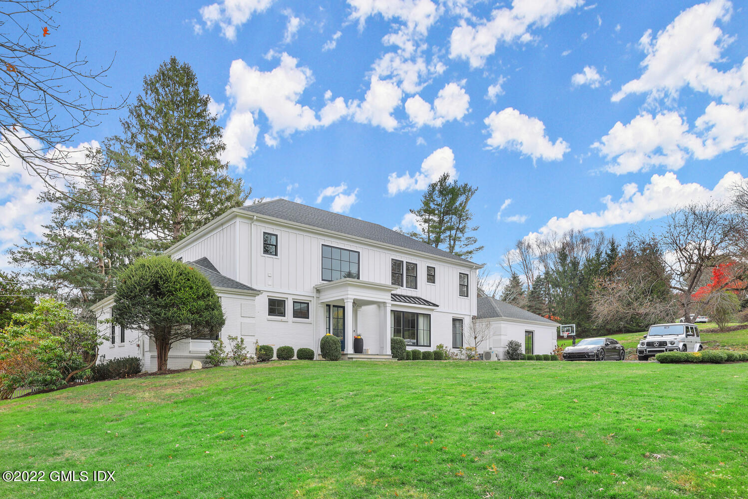 14 Copper Beech Road Greenwich, CT 06830 - Photo 45 of 48 a view of a white house in front of a big yard with large trees