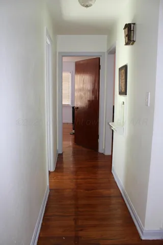 a view of a hallway with wooden floor