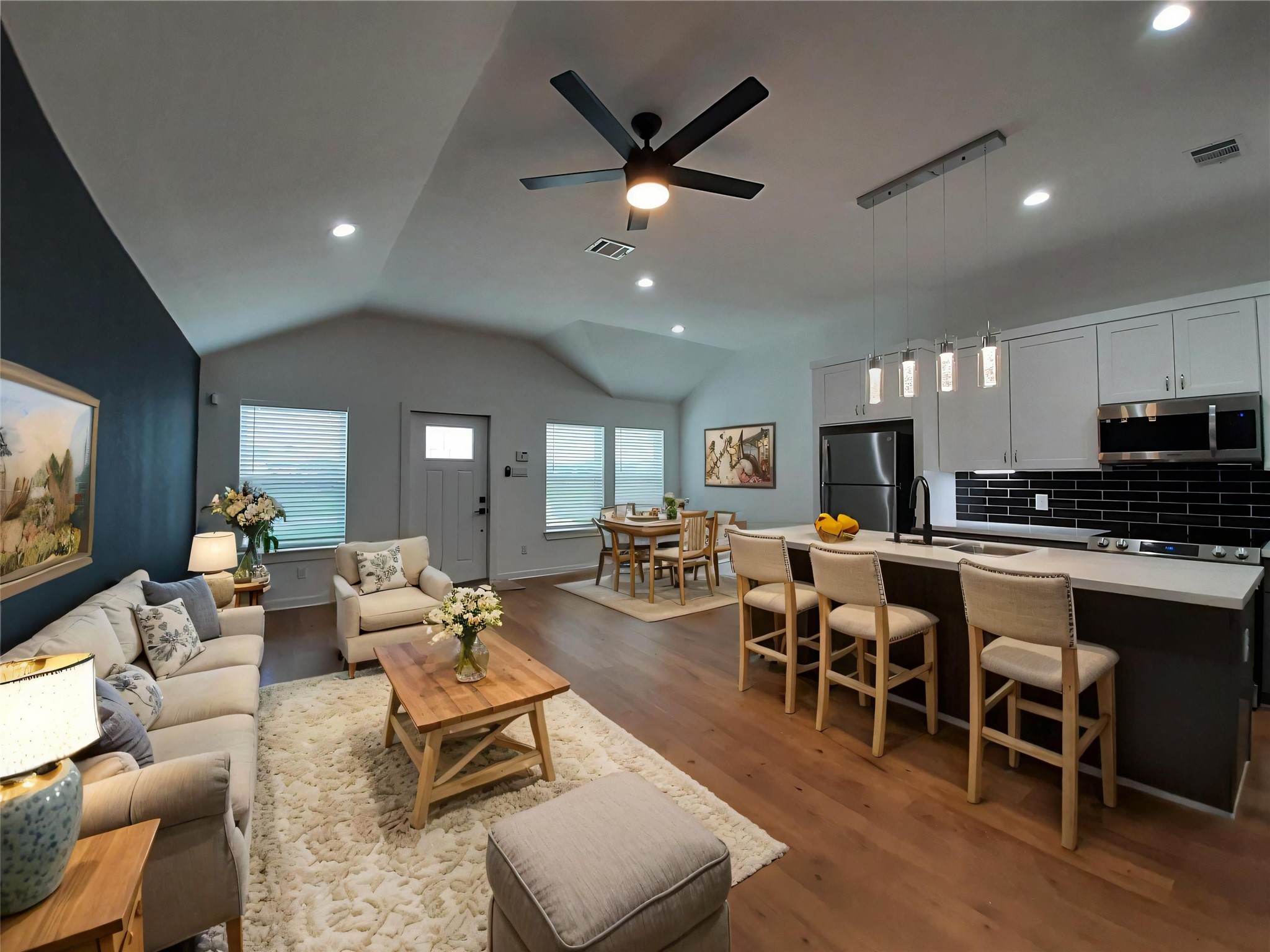 a living room with furniture kitchen view and a flat screen tv